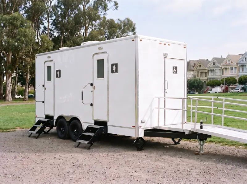 ADA restroom trailer with a wheelchair ramp and railings
