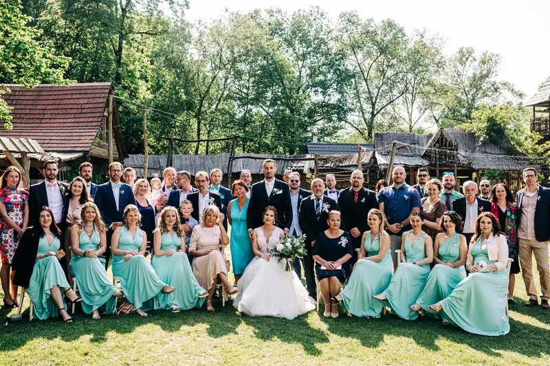 Wedding party and guests posing together at an outdoor reception