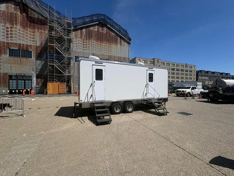 Lit restroom trailer at a nighttime event